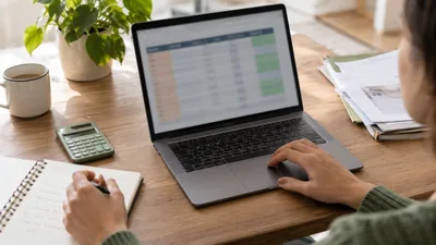 Une personne étudie son budget sur un ordinateur avec un carnet et une calculatrice — scène illustrative générée par IA